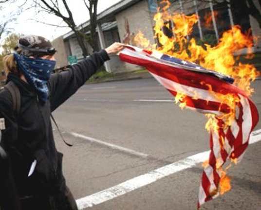 Joven quemando bandera estadounidense