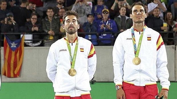 Rafa Nadal y Marc Lopez en el momento que reciben la medalla con la bandera separatista de fondo